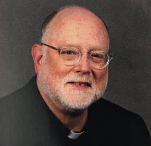 A person with glasses and a white beard

Description automatically generated
